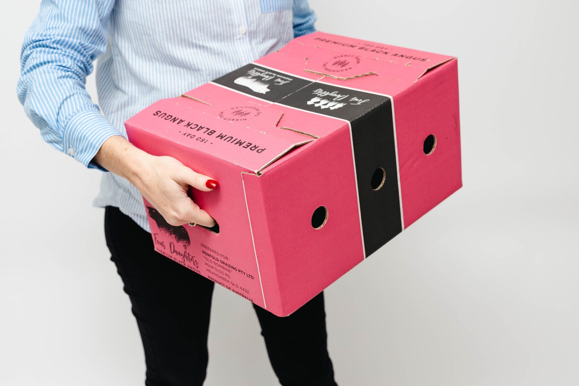 Person carrying two pink and black storage boxes with hand holes