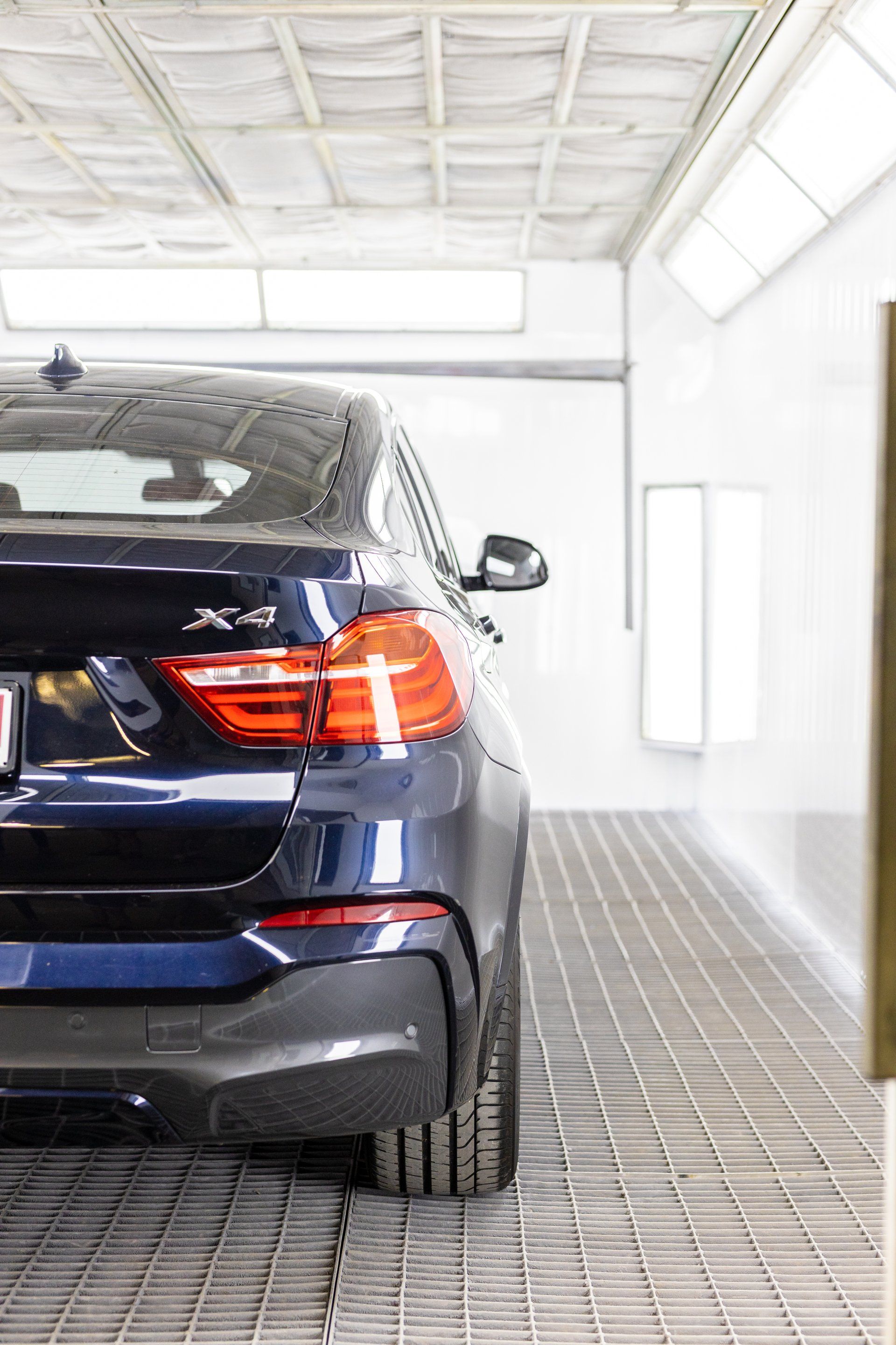Blue SUV parked in a bright indoor garage with tiled floor