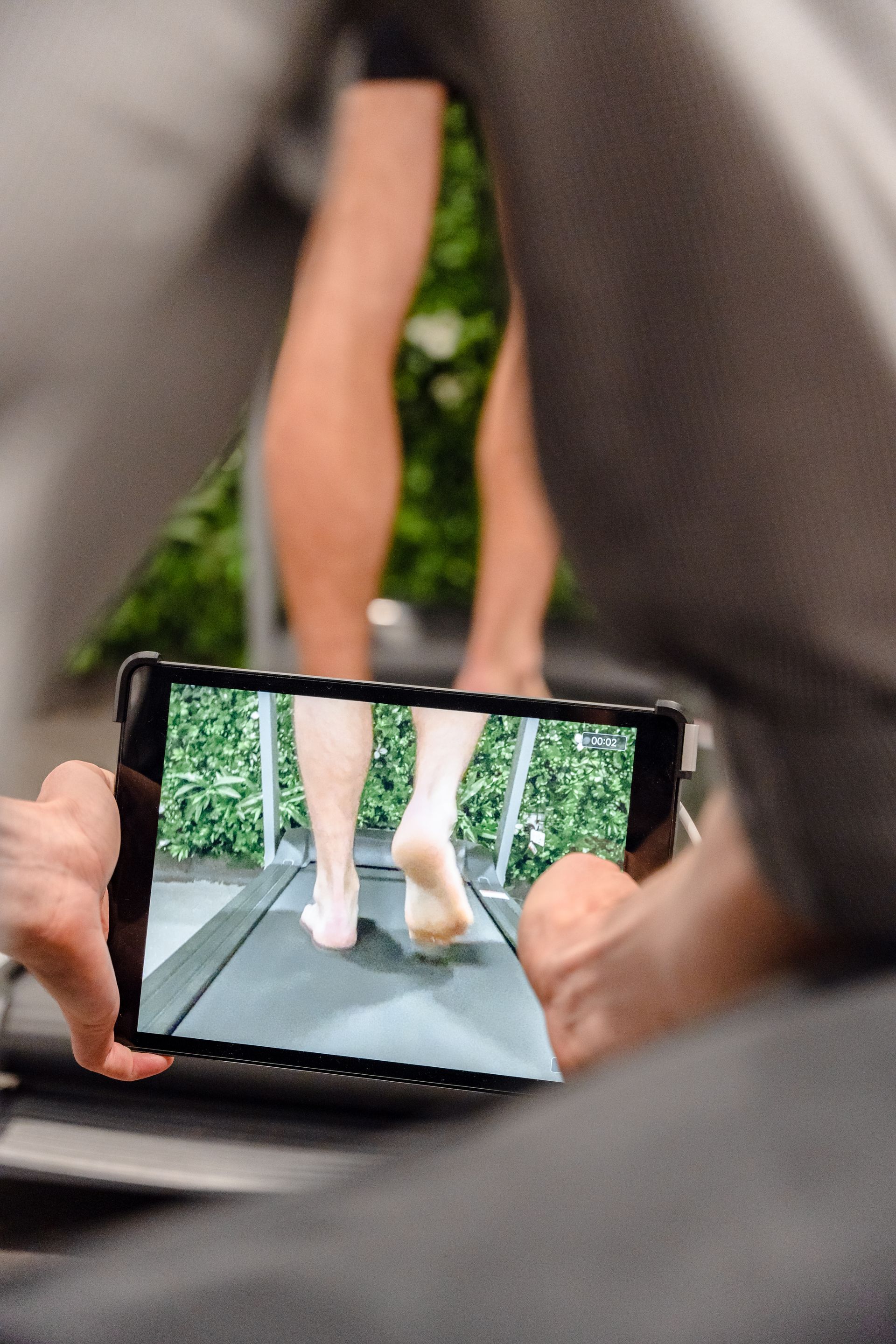 Person viewing a phone screen showing feet on a narrow path outdoors