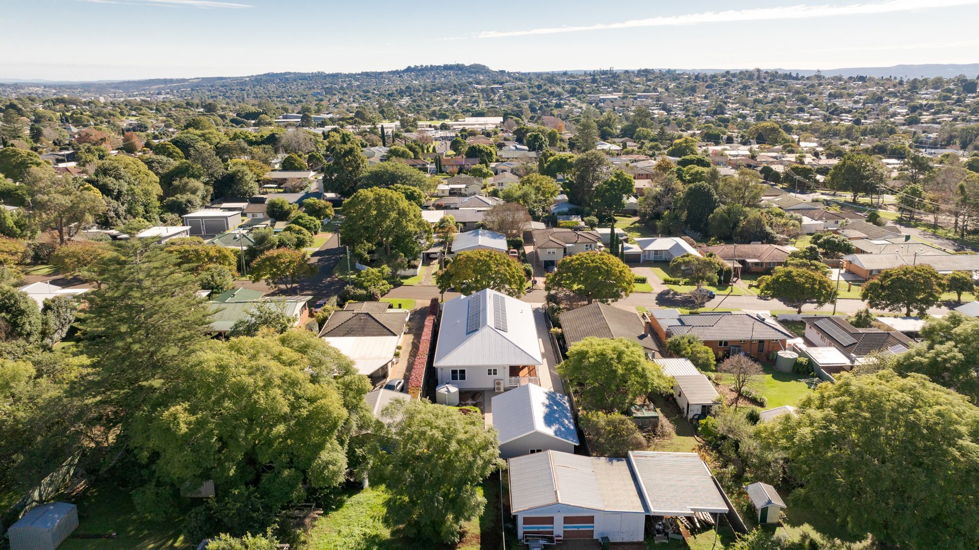 Aerial view of a leafy suburban neighborhood with houses and streets stretching to the horizon.