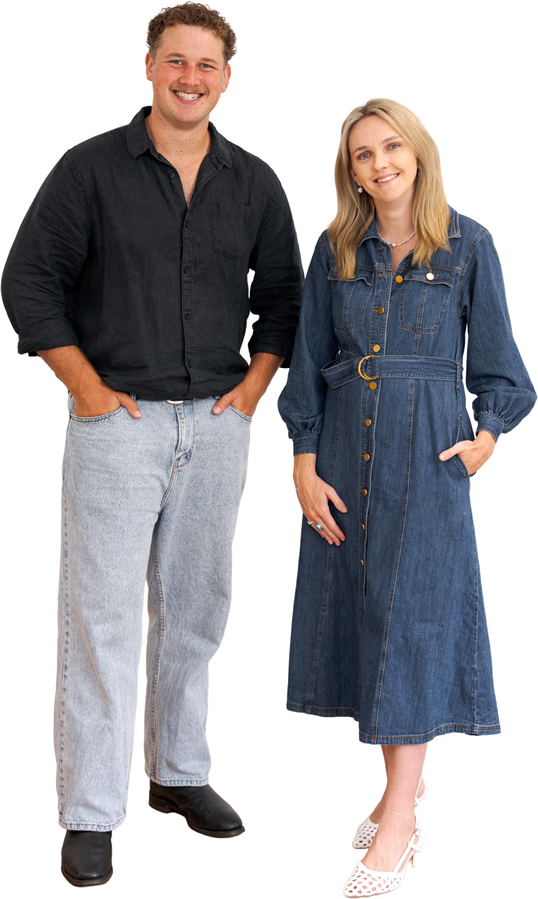 Two people posing in casual clothes, a man in a black shirt and gray pants beside a woman in a denim dress.