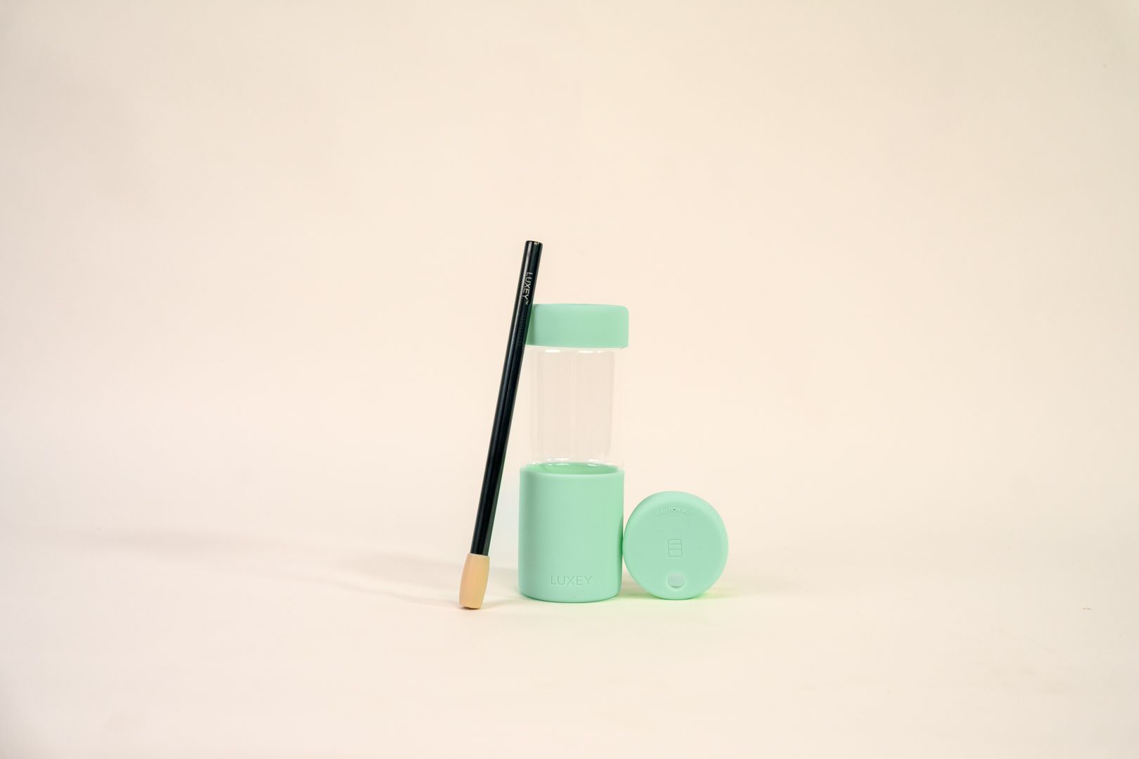 Green geometric shapes with a black pencil against a beige background