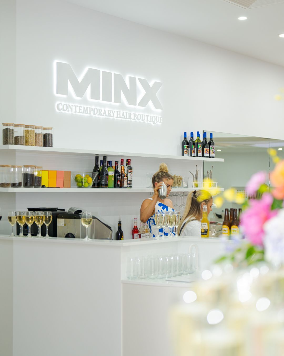 Bright white café or bar interior with a glowing “MIXX” sign and a person behind the counter