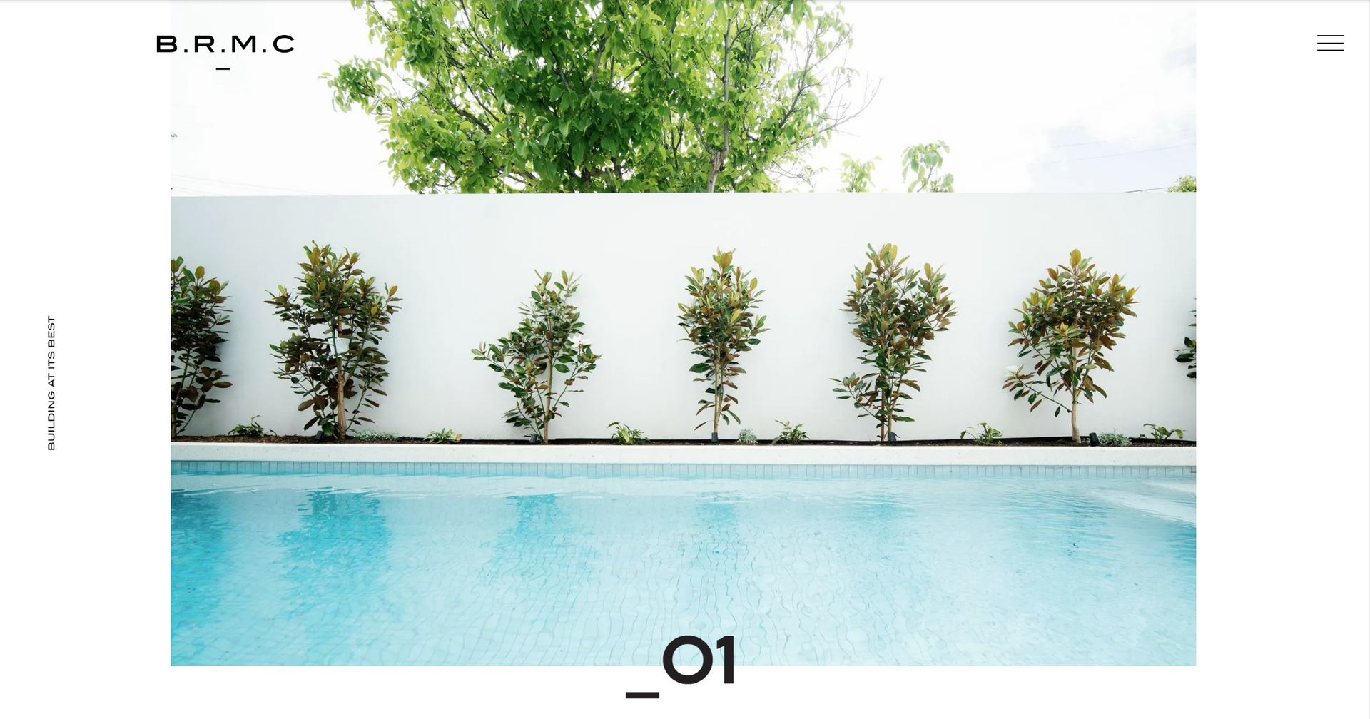 Minimalist pool courtyard with white wall, potted plants, and turquoise water