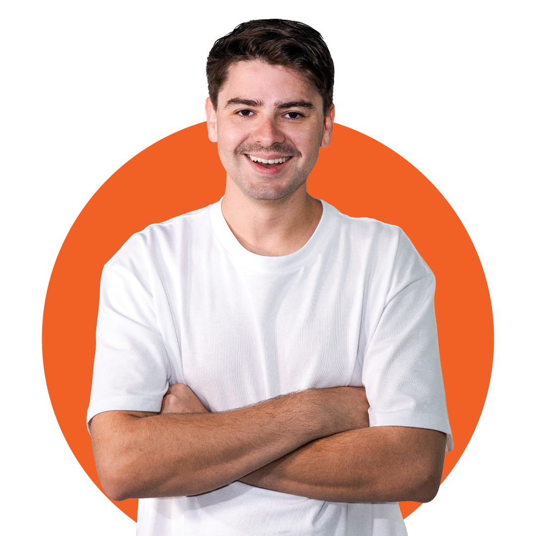 Smiling person in a white T-shirt with arms crossed in front of an orange circle background