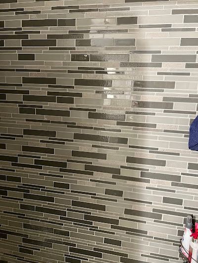 Gray and black rectangular tile shower wall.