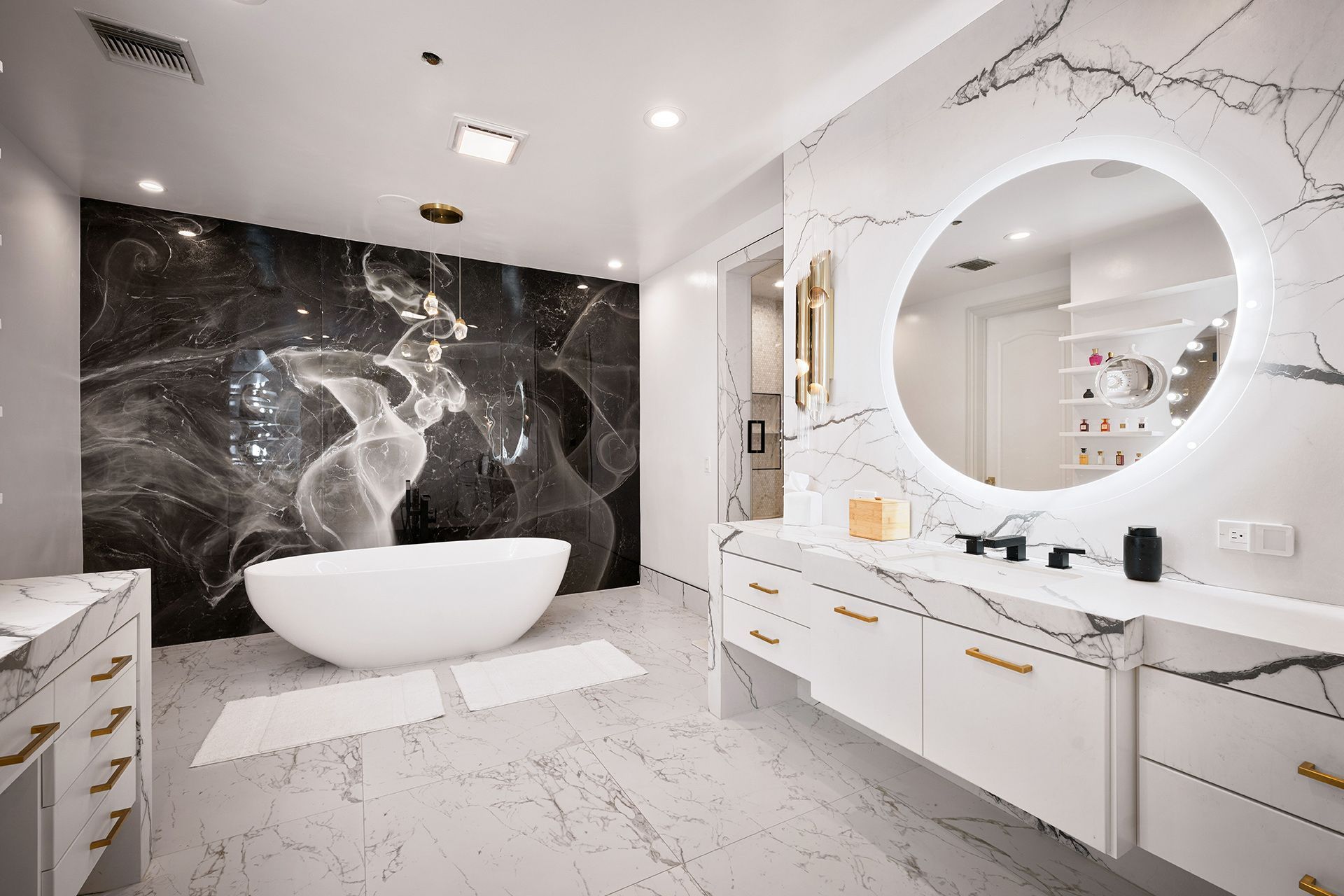 Luxurious bathroom with marble surfaces, a soaking tub, and a dramatic black and white art piece.