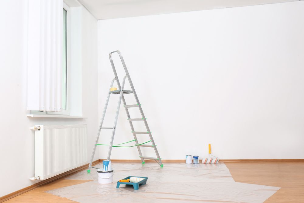 An Empty Room With A Ladder , Paint , And Rollers For Painting — Yves De Wilde Quality Painting Services In Mullumbimby, NSW