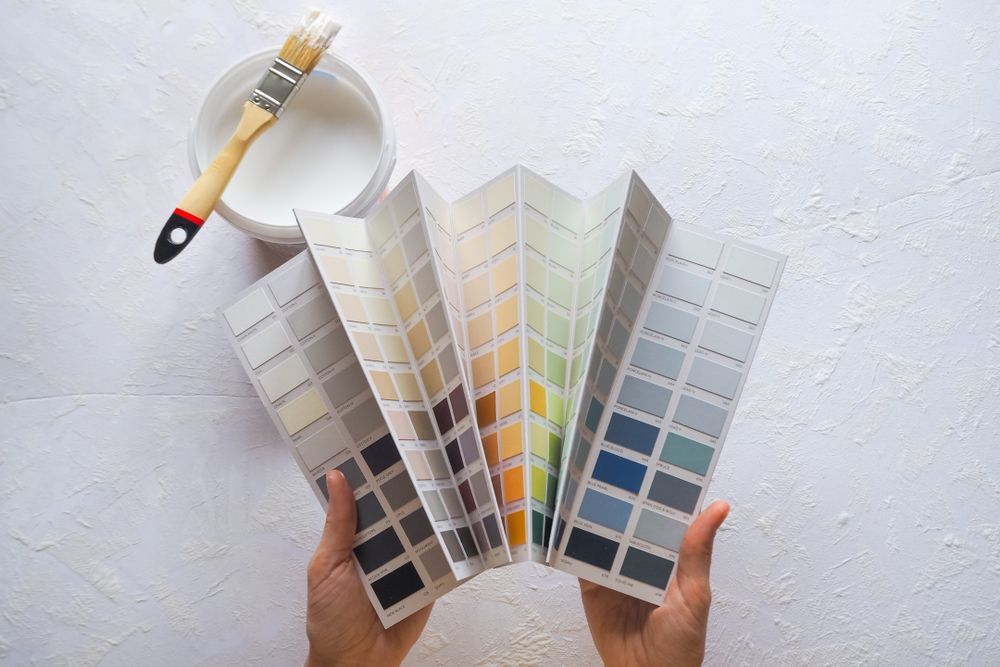 Two Hands Holding A Paint Color Swatch Fan