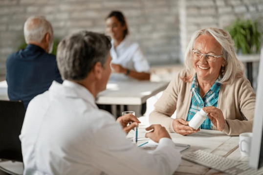 People talking at a café table, smiling and gesturing during a meeting