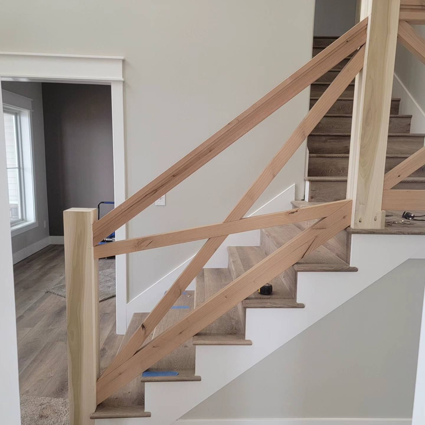 A wooden railing on a set of white stairs