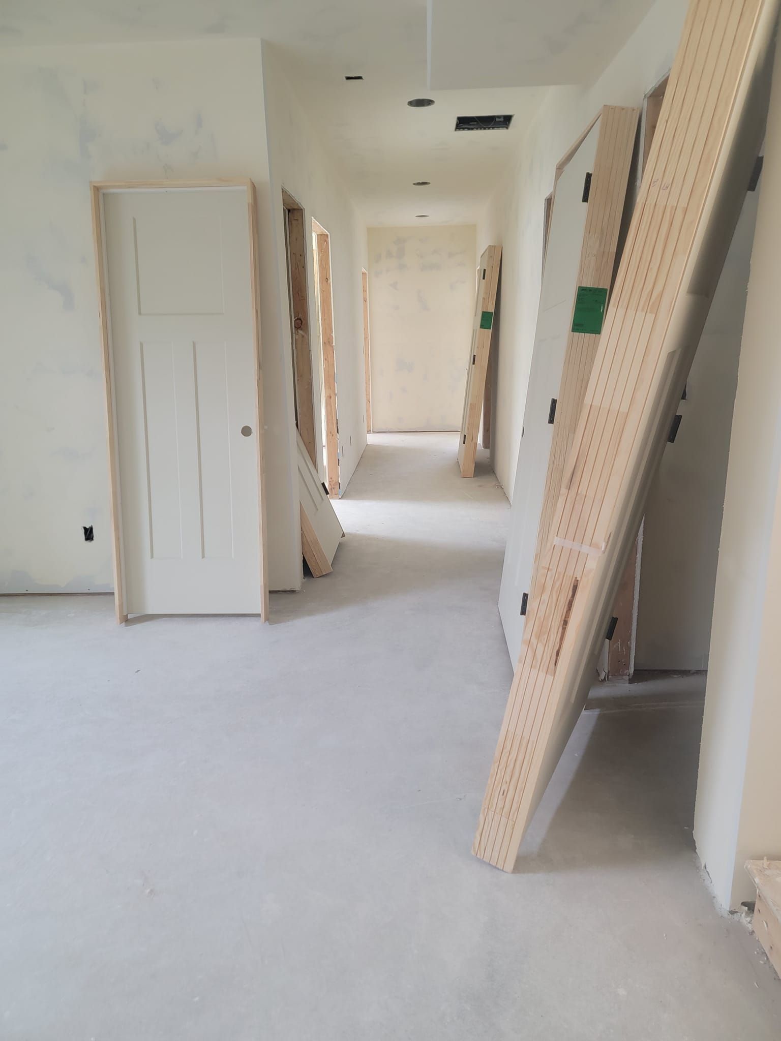 A hallway in a house under construction with wooden boards on the floor