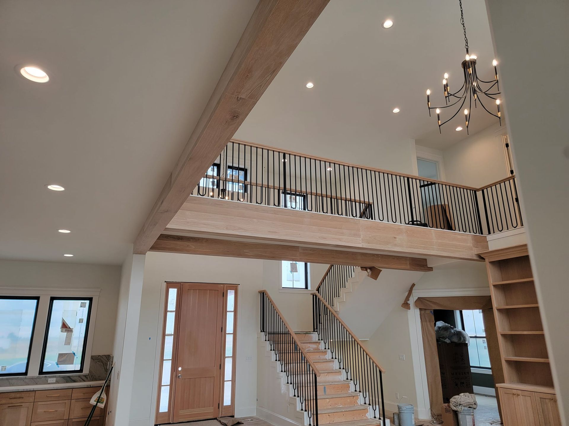 A large room with a staircase and a chandelier hanging from the ceiling.