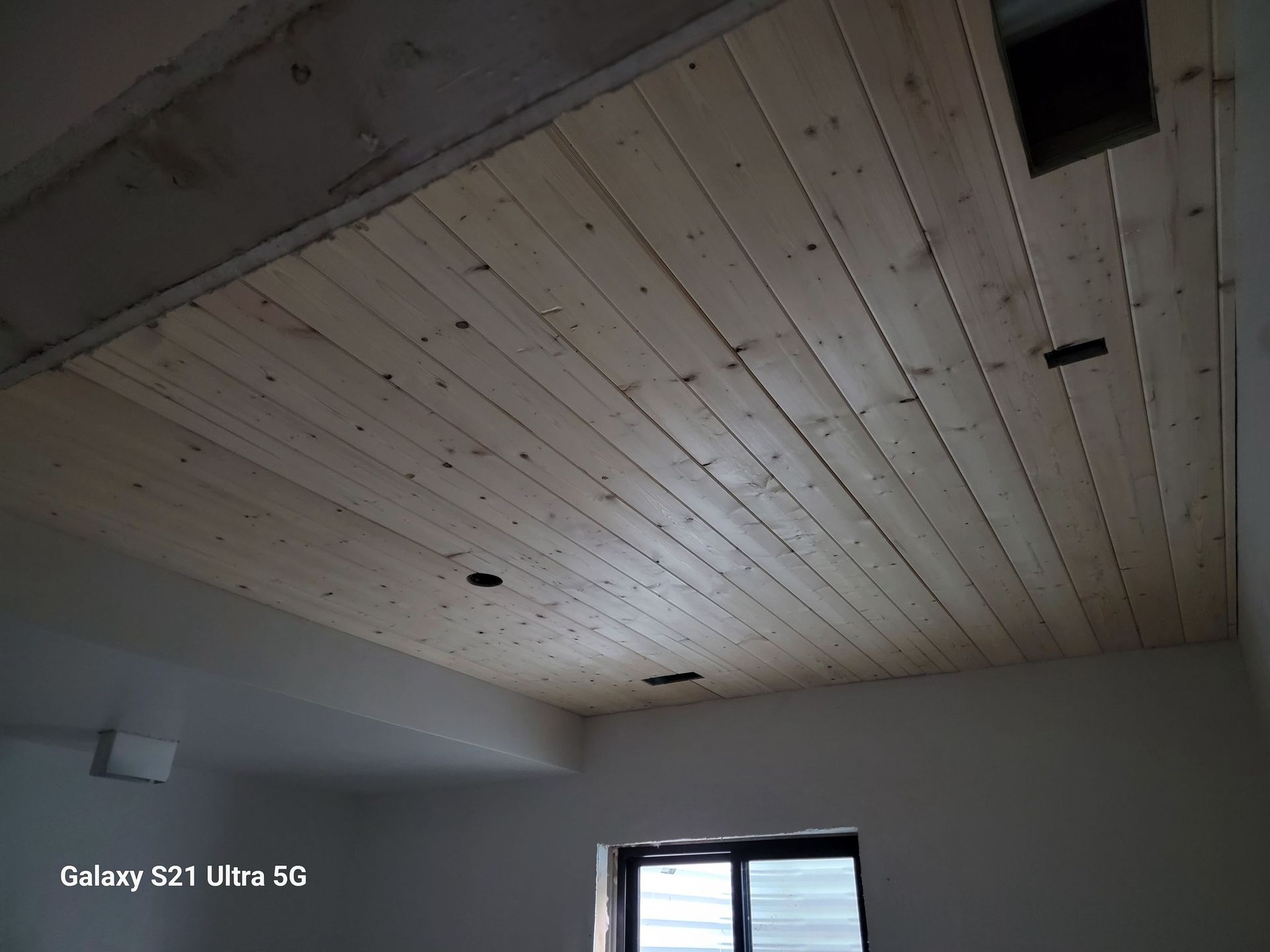 A room with a wooden ceiling and a galaxy s21 ultra 5g