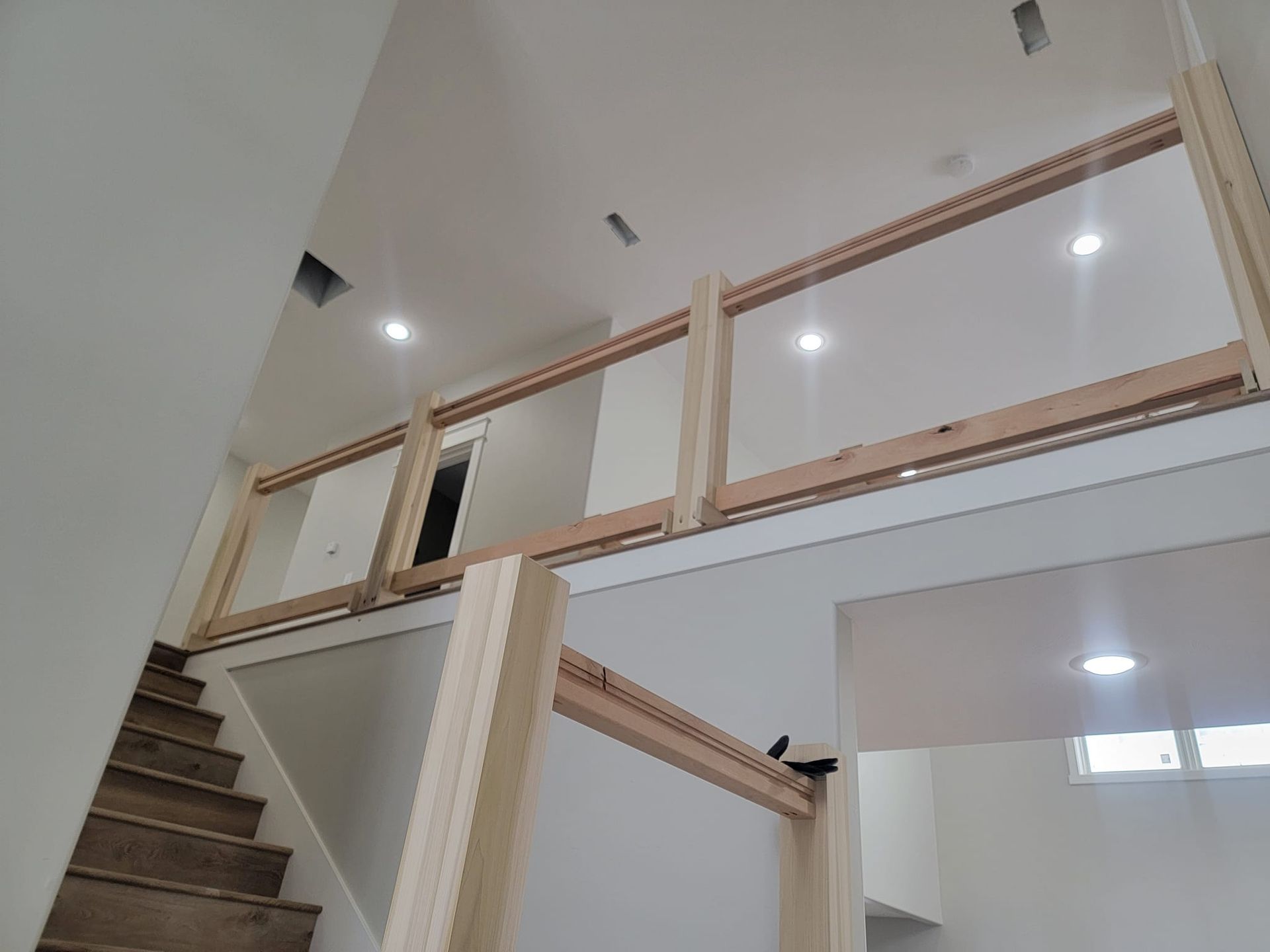 A staircase with a wooden railing and a glass railing in a house.