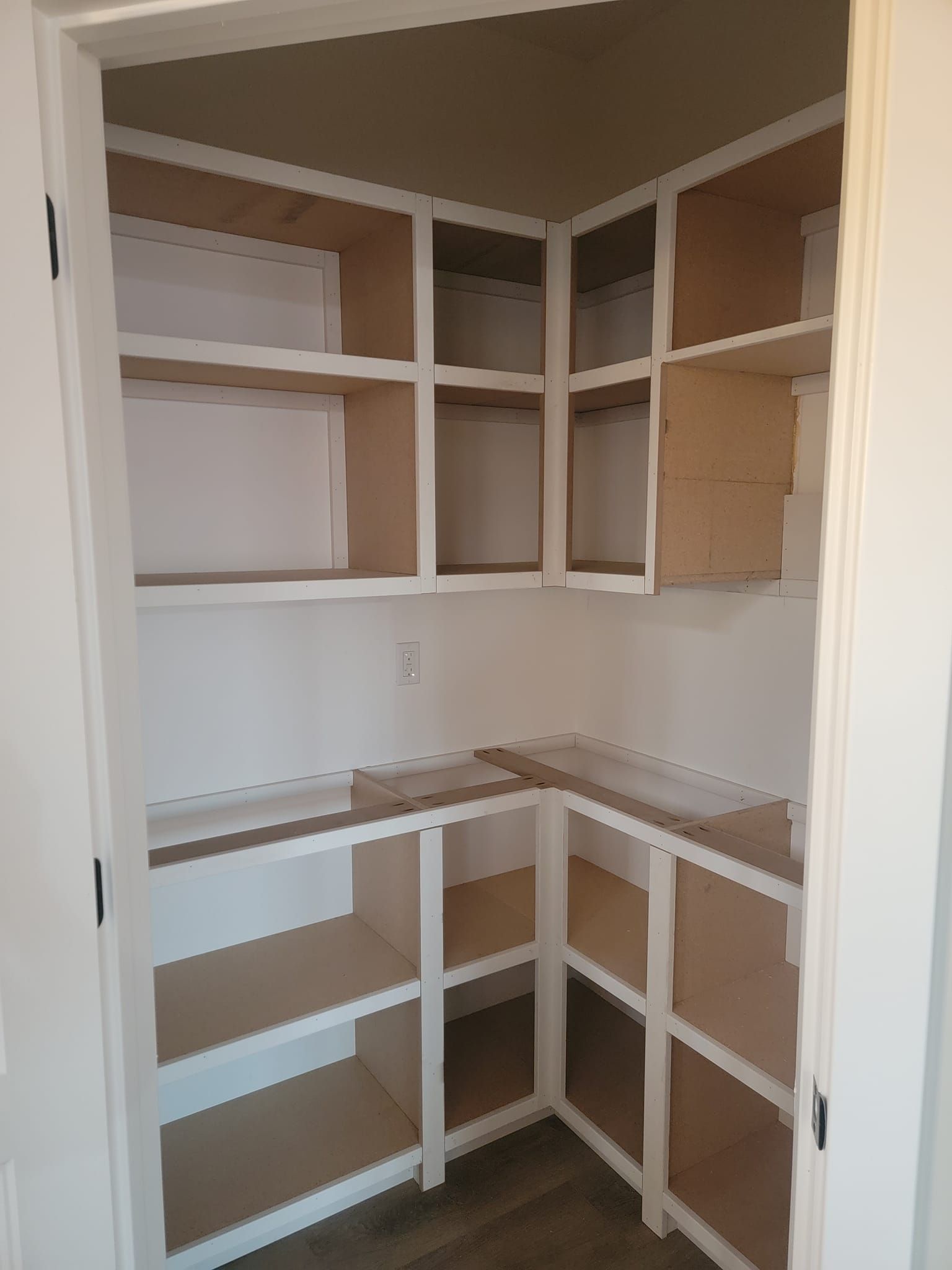 A pantry with a lot of shelves and a door.
