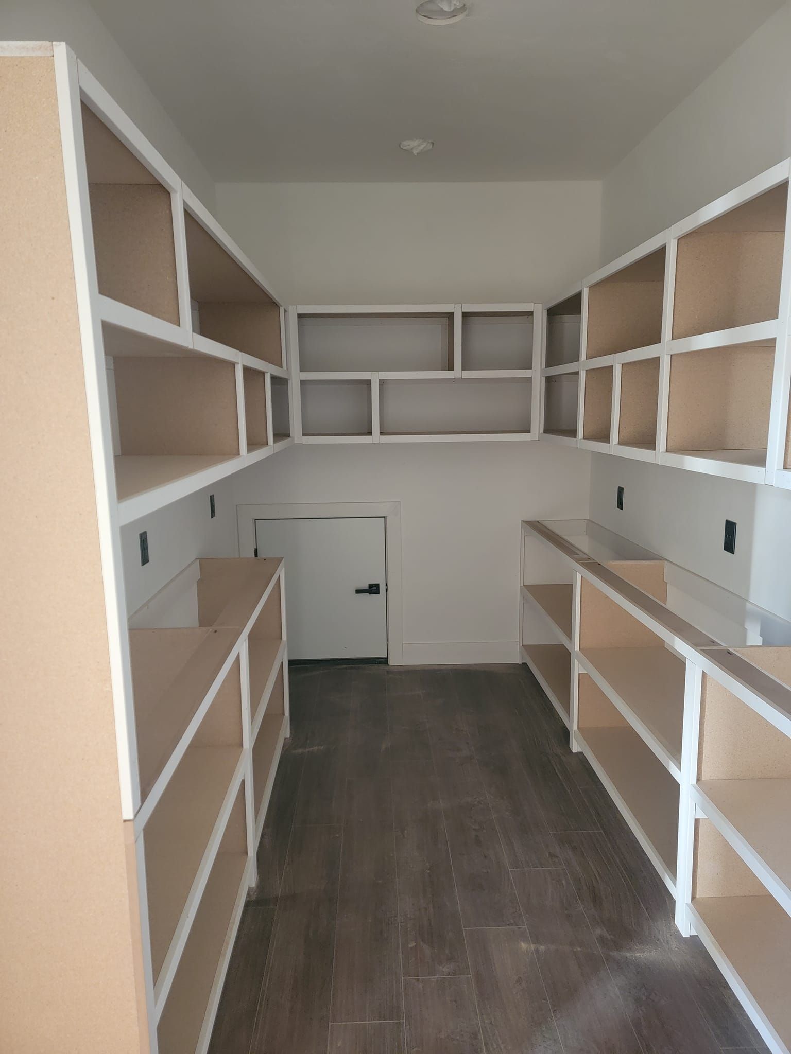 A room with a lot of shelves and a door