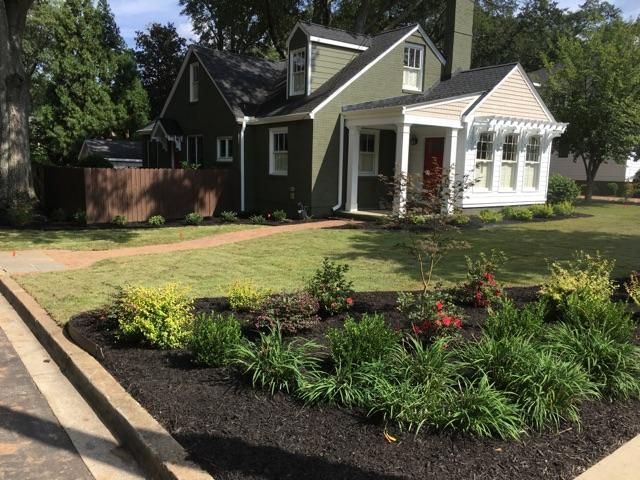 A house with a lot of plants in front of it