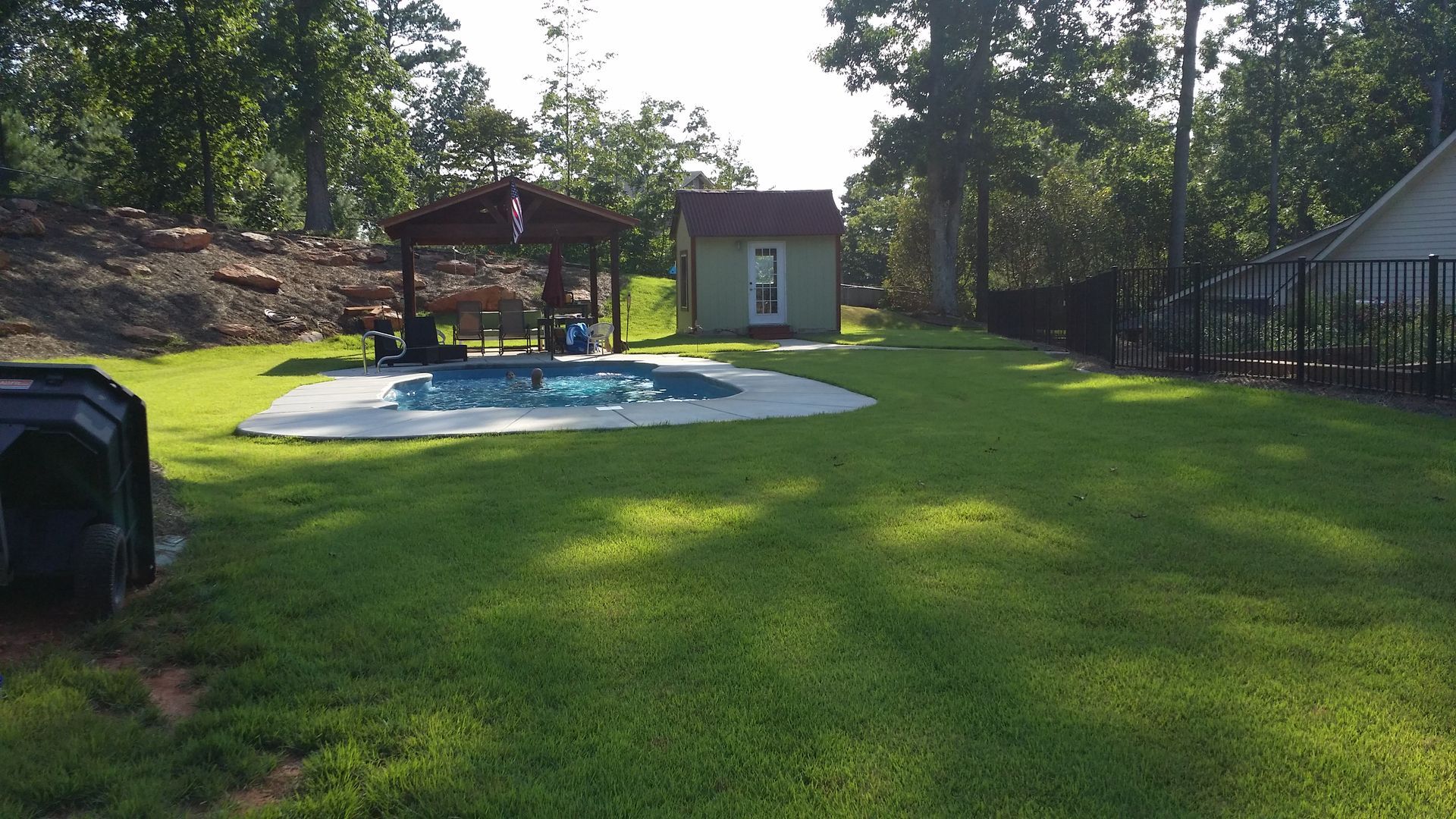 A backyard with a swimming pool and a shed