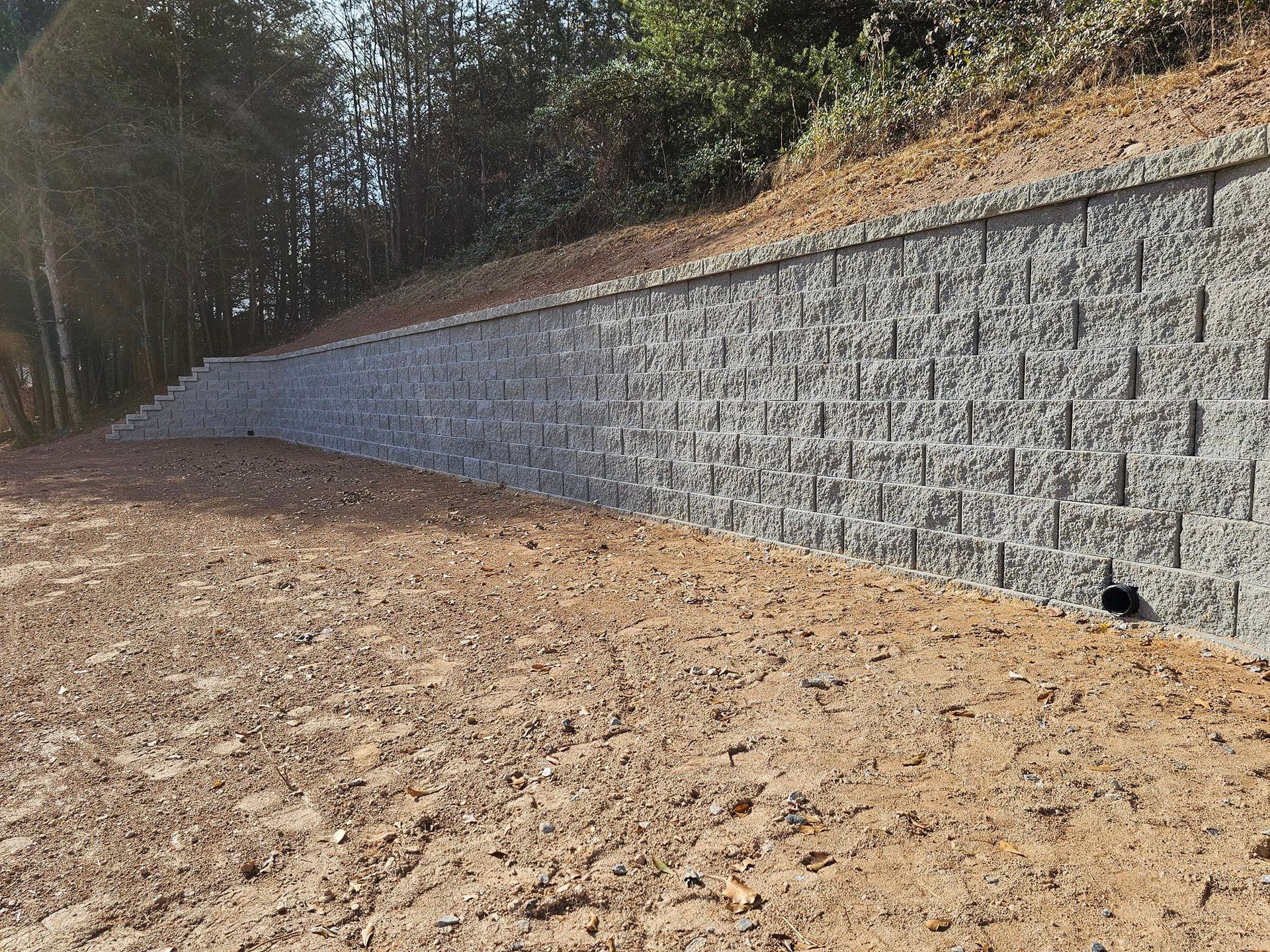 A large stone wall is sitting on top of a dirt hill spartanburg 