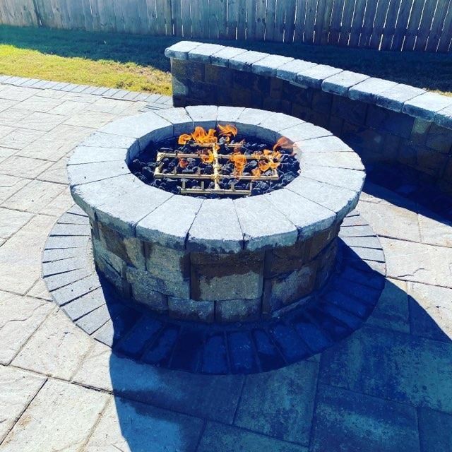 A fire pit on a patio with a fence in the background Boiling springs 