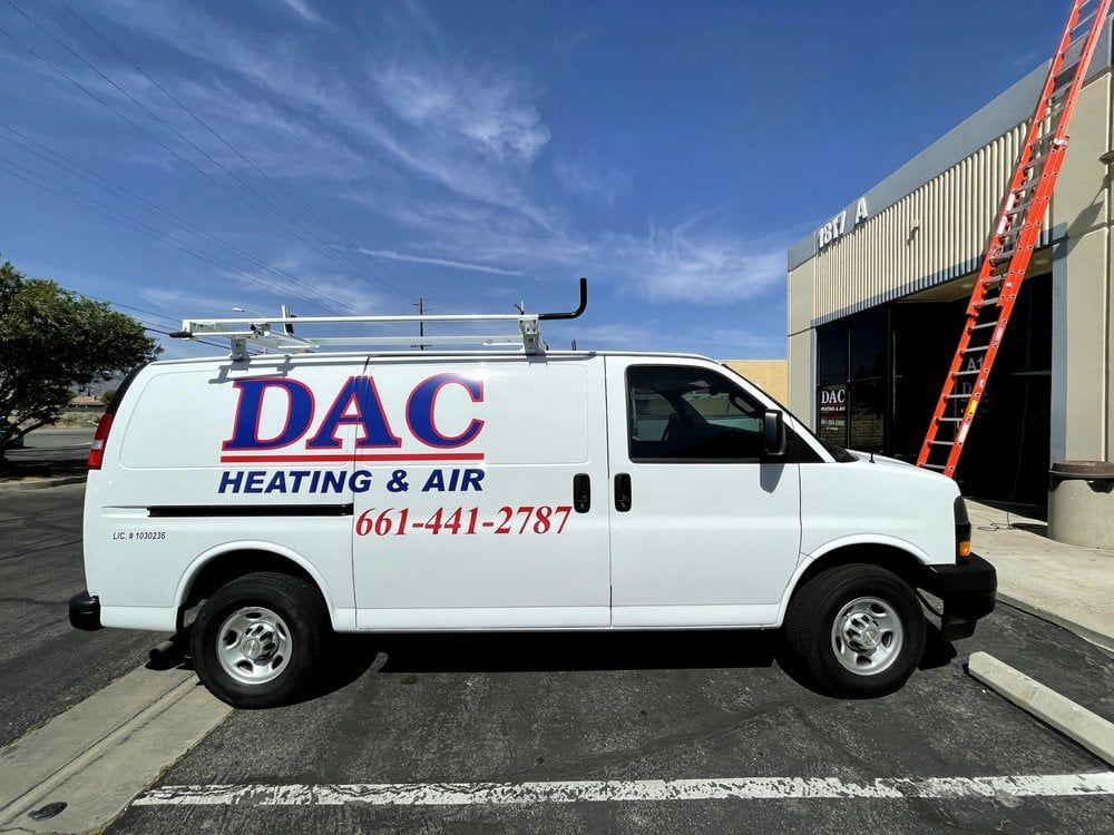 A white dac heating and air van is parked in a parking lot