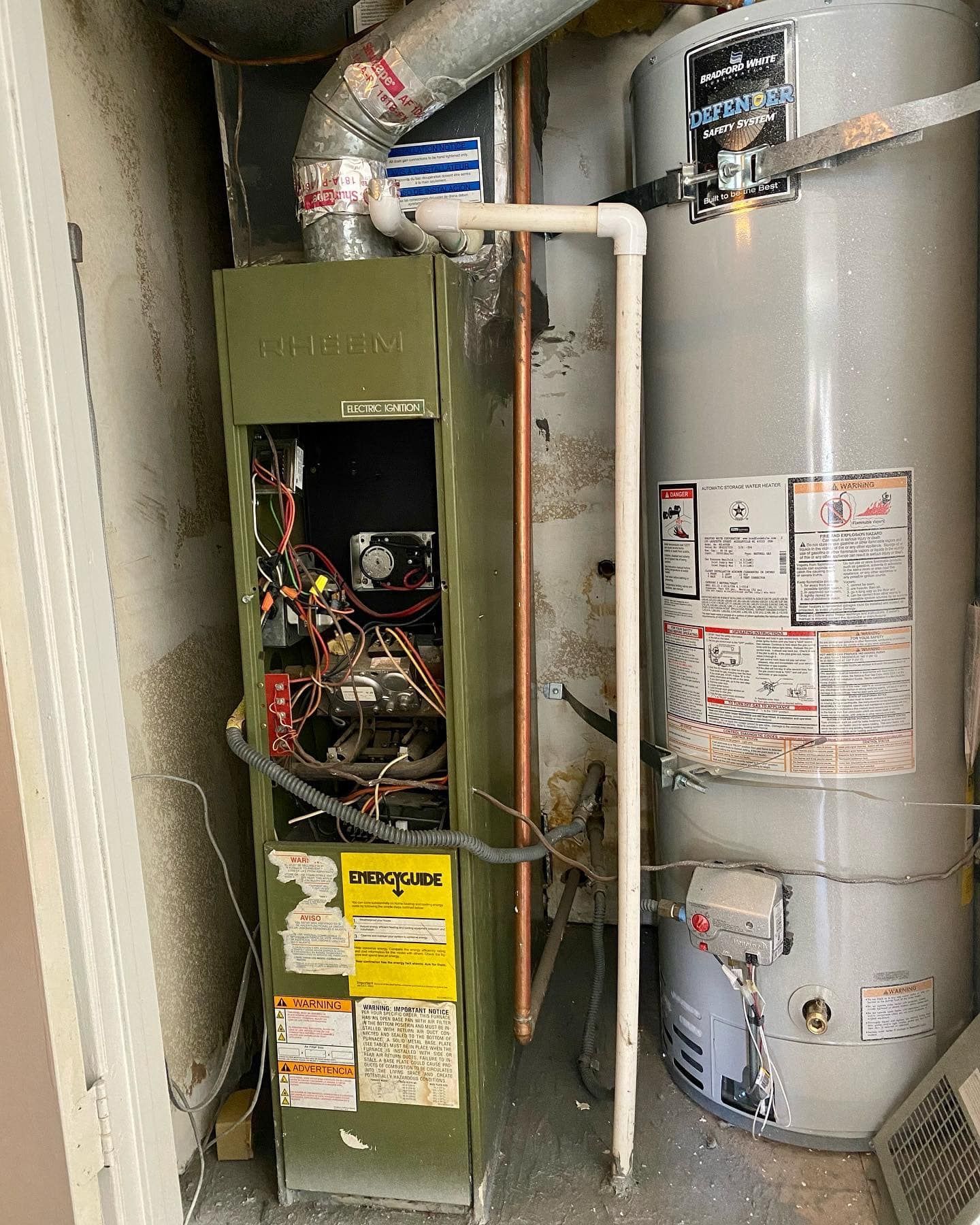A water heater and an air conditioner are sitting next to each other in a room.