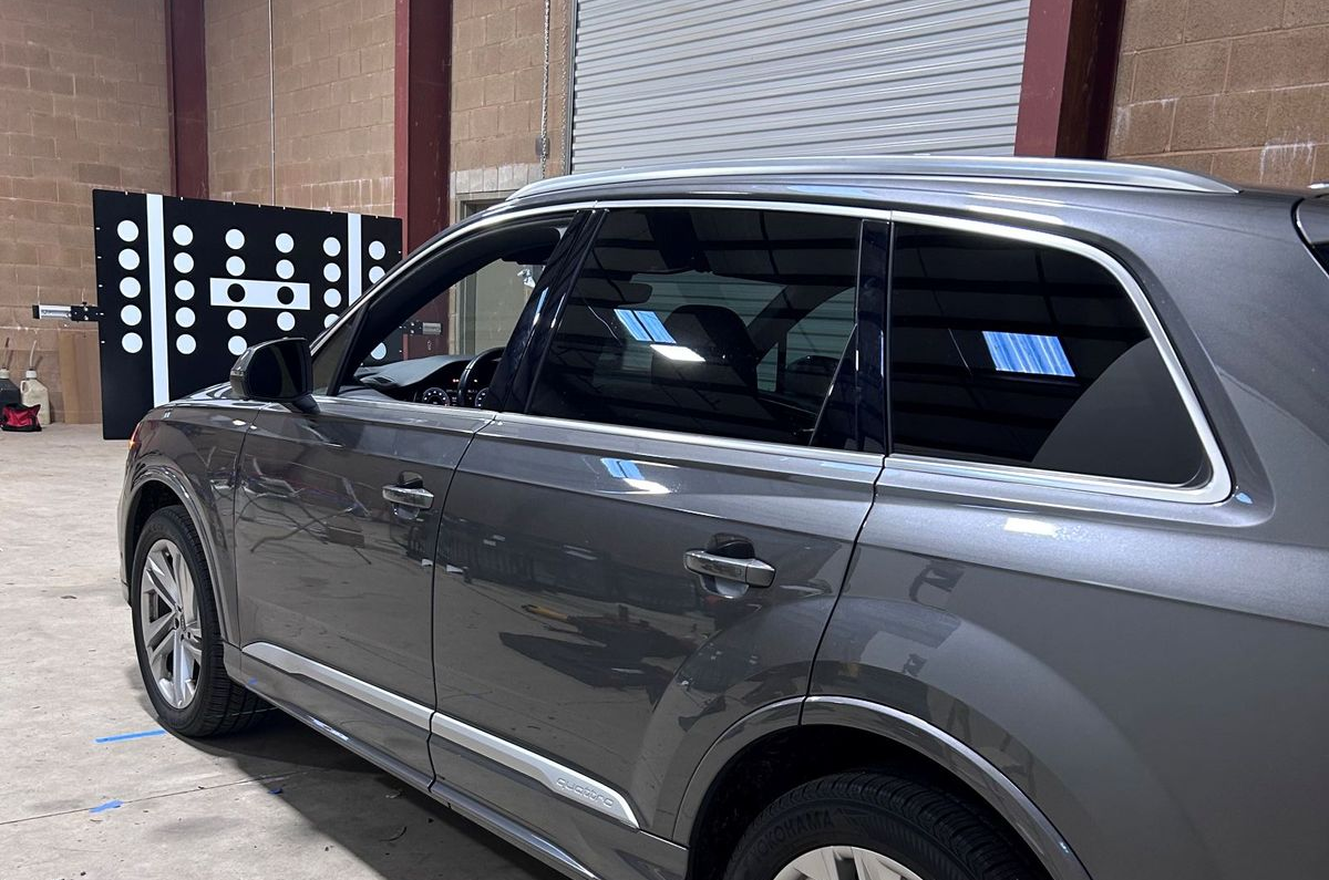 Gray SUV parked indoors beside a black display wall.