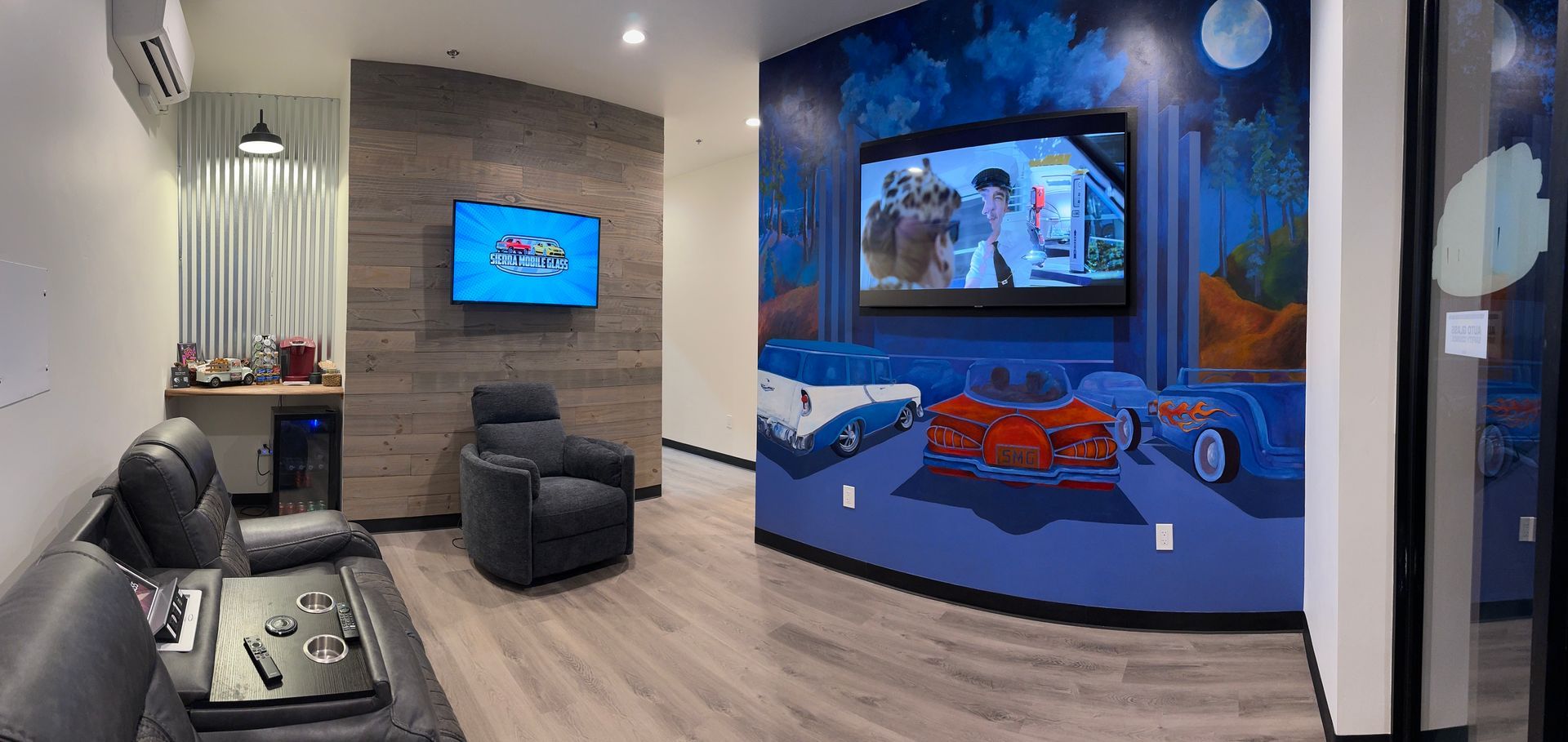 Mobile & in-shop auto glass repair service in Truckee & Sierra, CA Modern living room media space with black leather seating and a large curved blue aquarium wall panel
