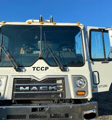 Semi & fleet windshield replacement in Truckee, CA Front view of a white Mack truck with open door, parked outdoors under a blue sky.