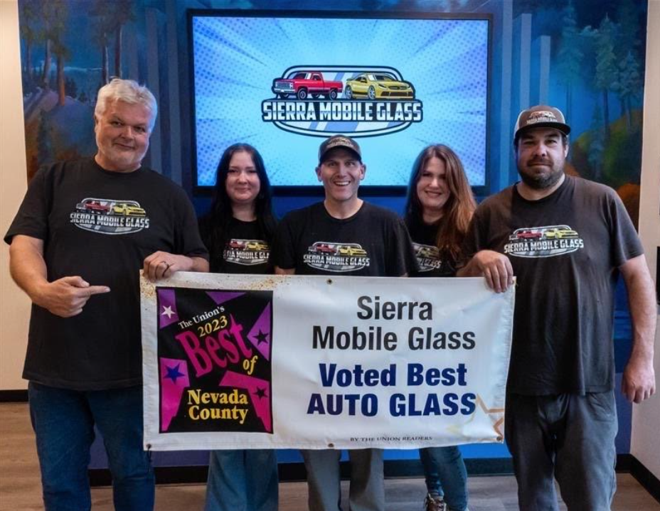 Five people holding a Sierra Mobile Glass “Voted Best Auto Glass” banner and Nevada County award plaque.