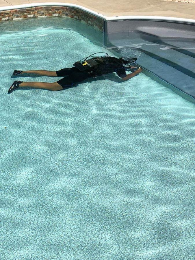 A Man Is Laying On His Back In A Swimming Pool — Col Davies Pools In Warners Bay, NSW