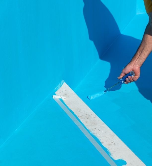 A Man Is Painting A Swimming Pool With A Brush — Col Davies Pools In Warners Bay, NSW