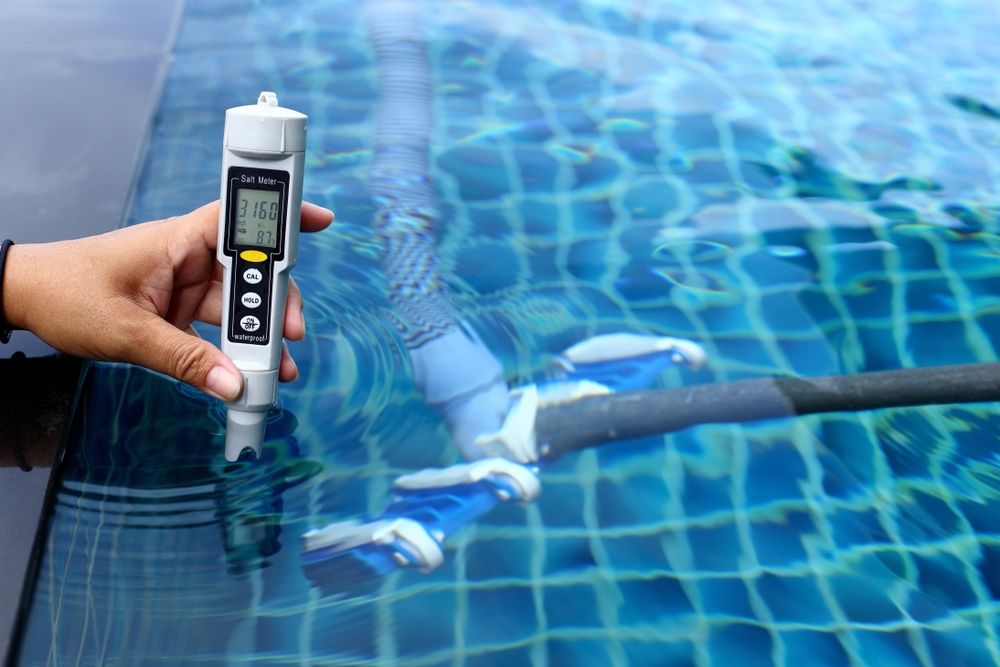 A Person Is Holding A Salt Meter Over A Swimming Pool — Col Davies Pools In Lake Macquarie, NSW