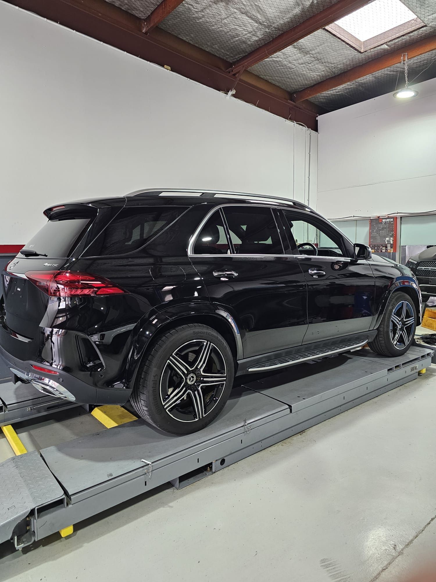 A Black Car is Sitting on a Lift in a Garage — Capital Automotive Service in Fyshwick, ACT