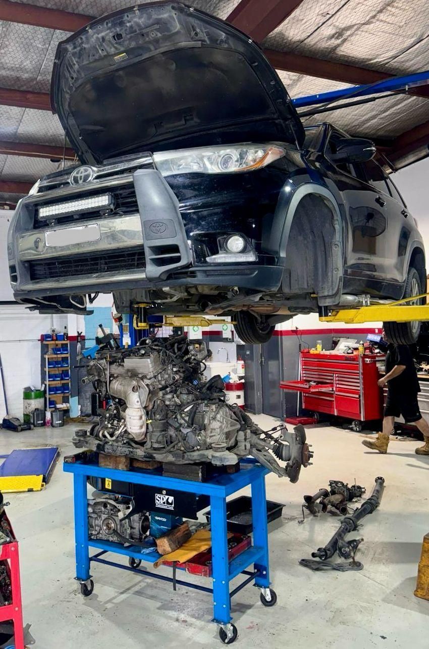 A Man is Working on the Engine of a Car With a Wrench — Capital Automotive Service in Fyshwick, ACT