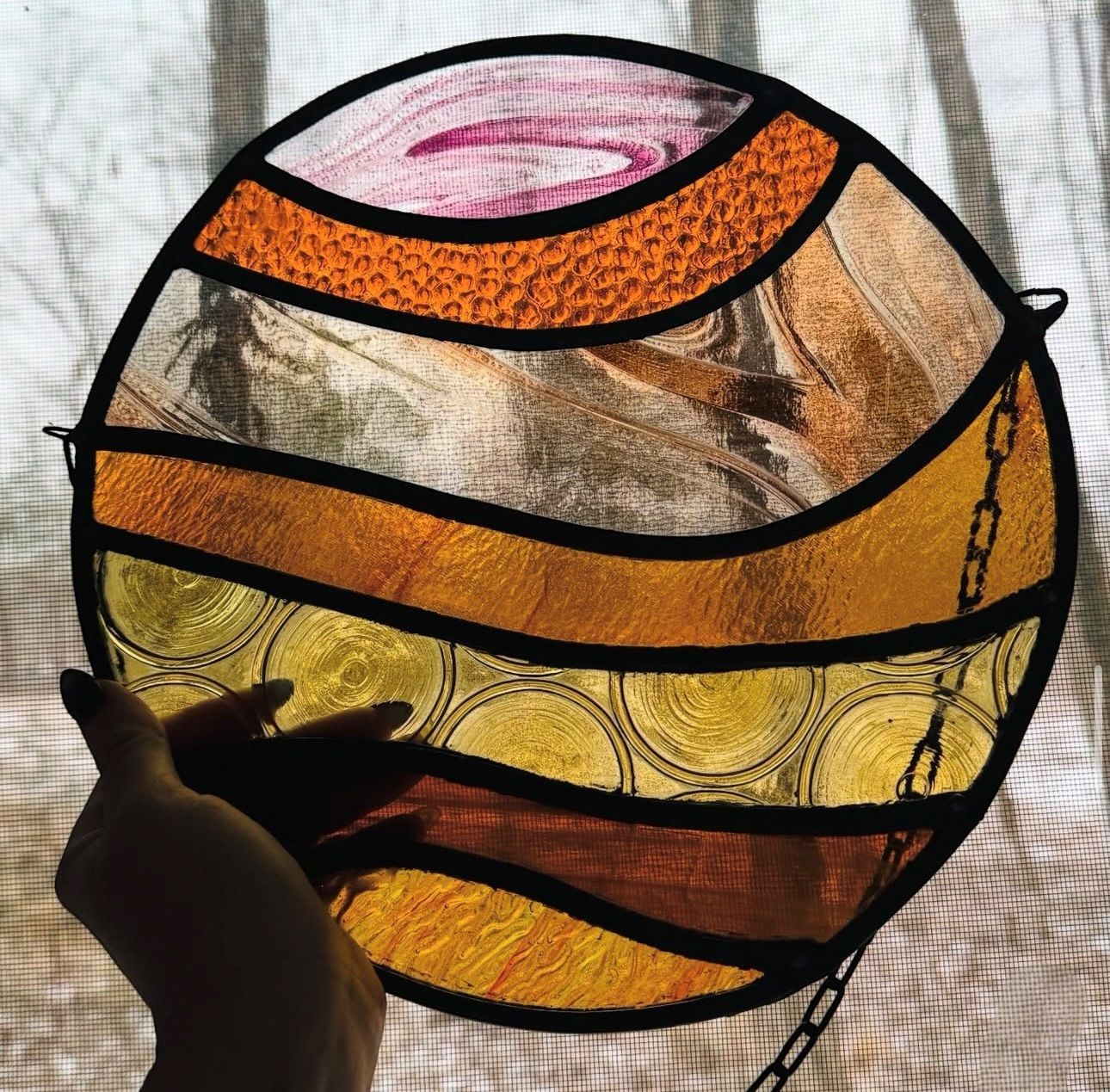 Colorful stained-glass floral window set in a stone wall
