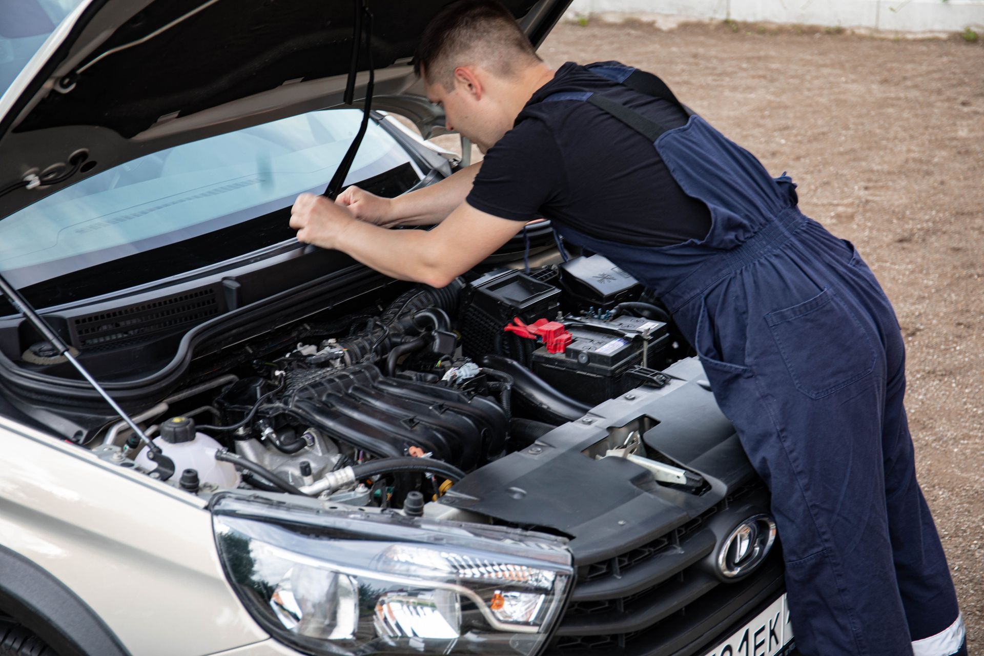 Mechanic inspecting a car engine with the hood open