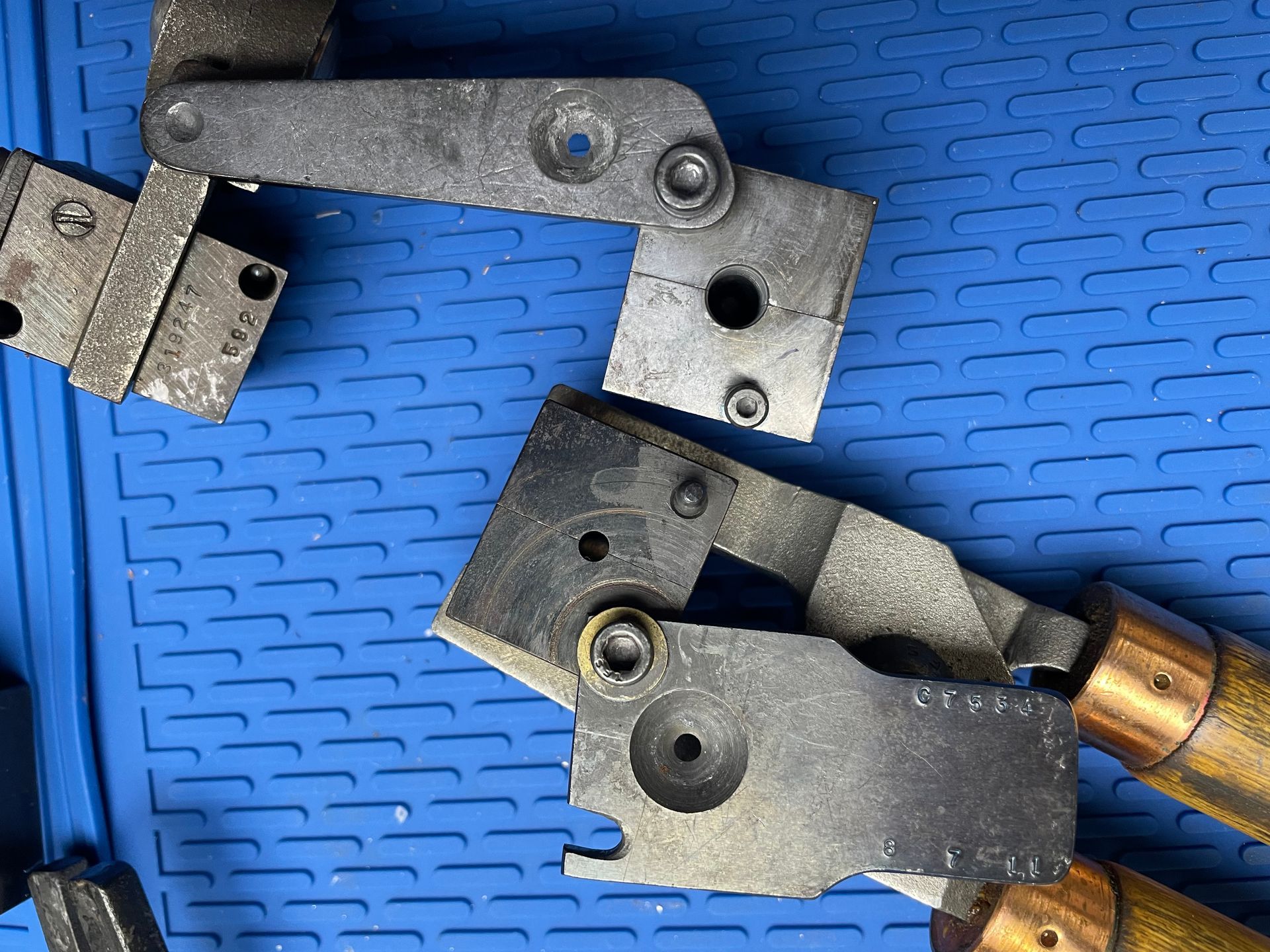 A pair of pliers are sitting on top of a blue mat.