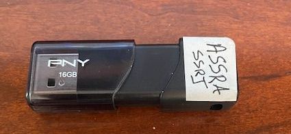 A pny 16gb flash drive is sitting on a wooden table.