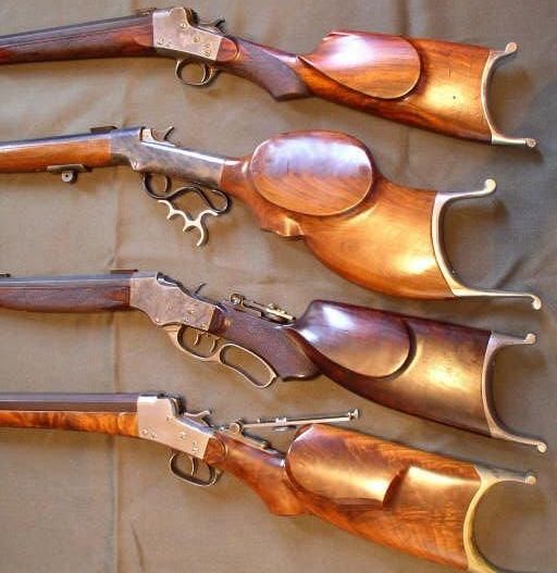 Four shotguns are lined up in a row on a table