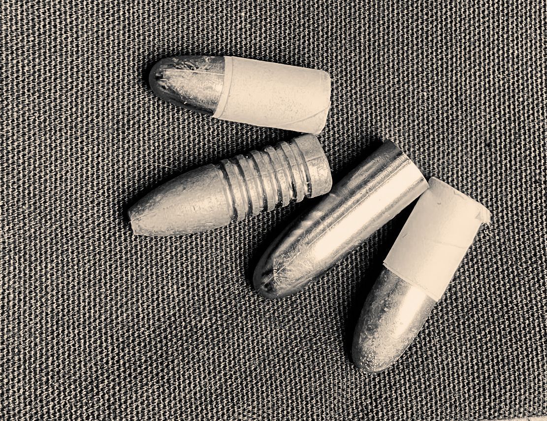 A black and white photo of three bullets on a table