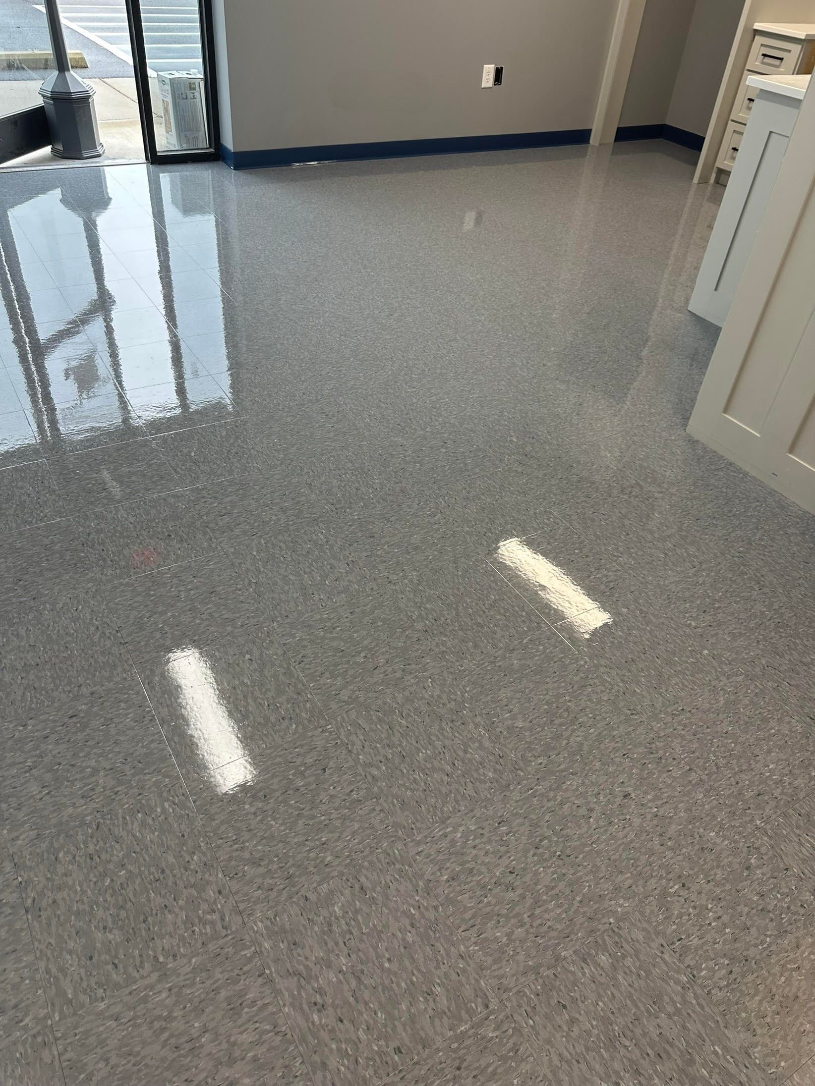 Gray speckled epoxy floor in a room with a window, white doors, and painted walls.
