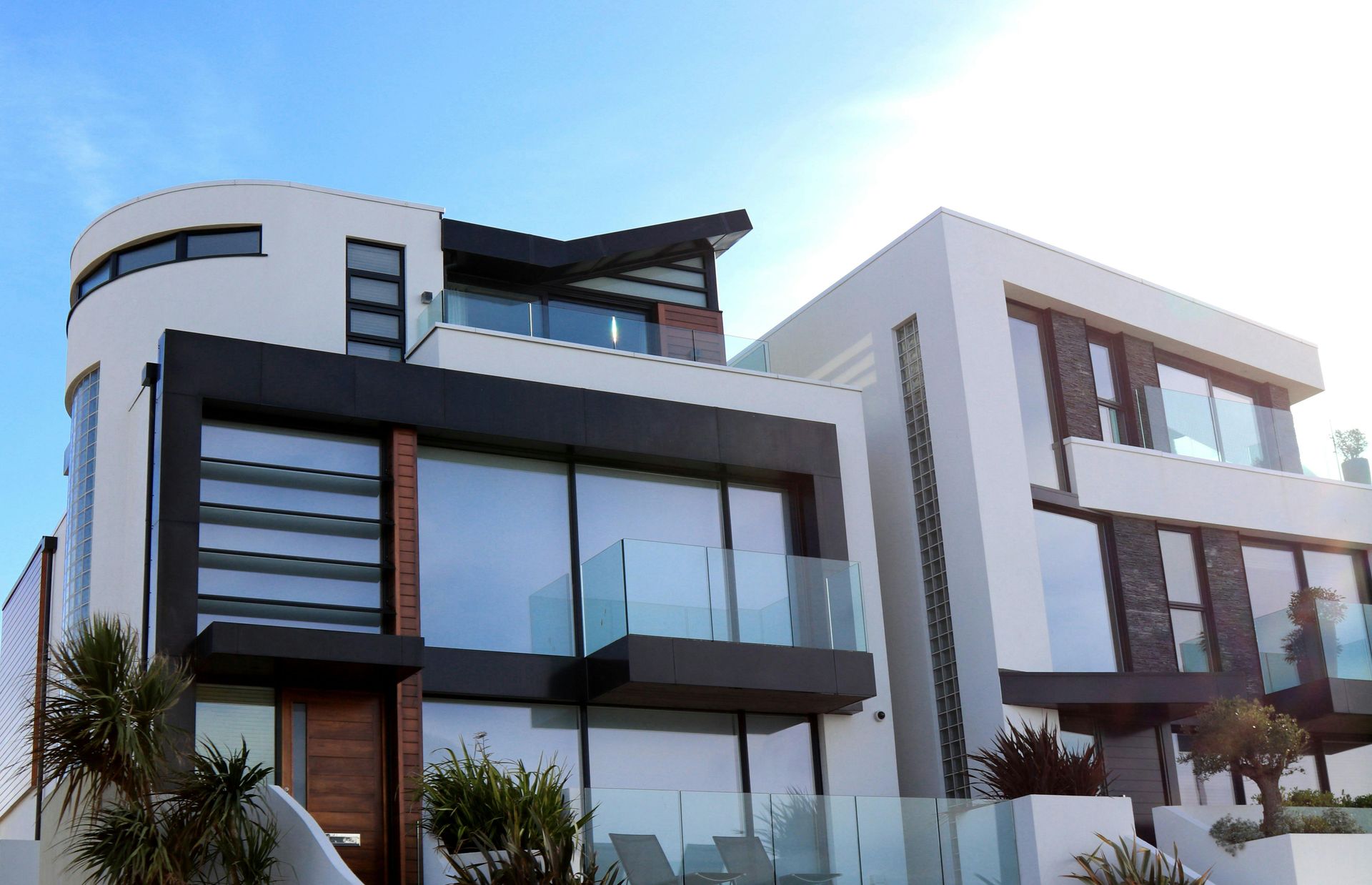 Modern white and gray contemporary houses with large windows under a clear blue sky