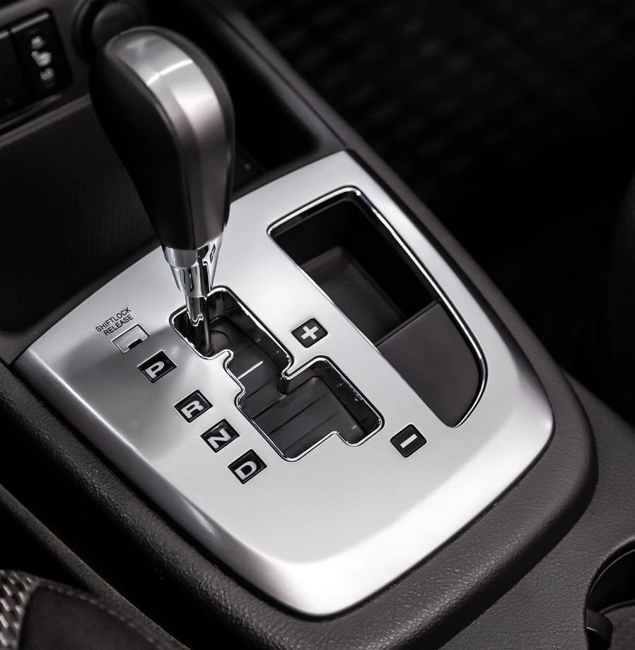 Primo piano del cambio automatico di un’auto, con finiture argentate e indicatore delle marce.