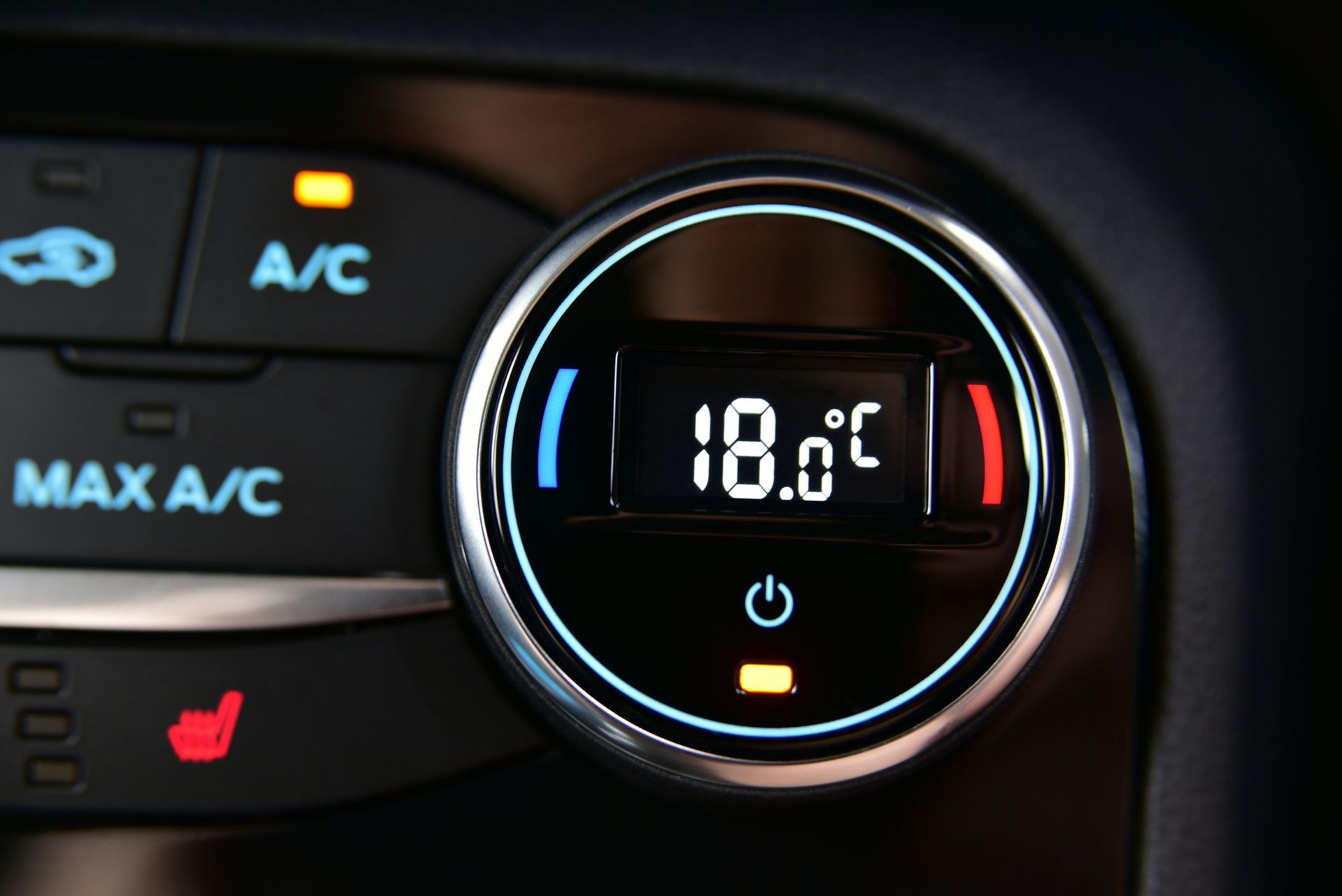 Display del climatizzatore dell’auto impostato su 18,0 °C, con gli indicatori dell’aria condizionata e del sedile riscaldato accesi