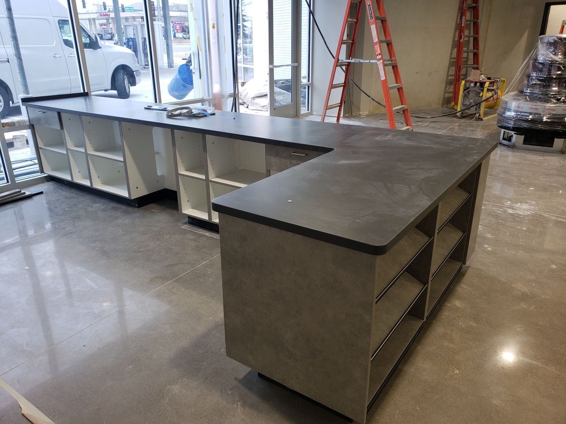 A large counter in a room with a ladder in the background.
