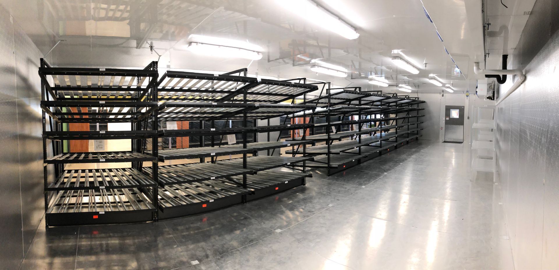 A warehouse filled with lots of shelves and a door.