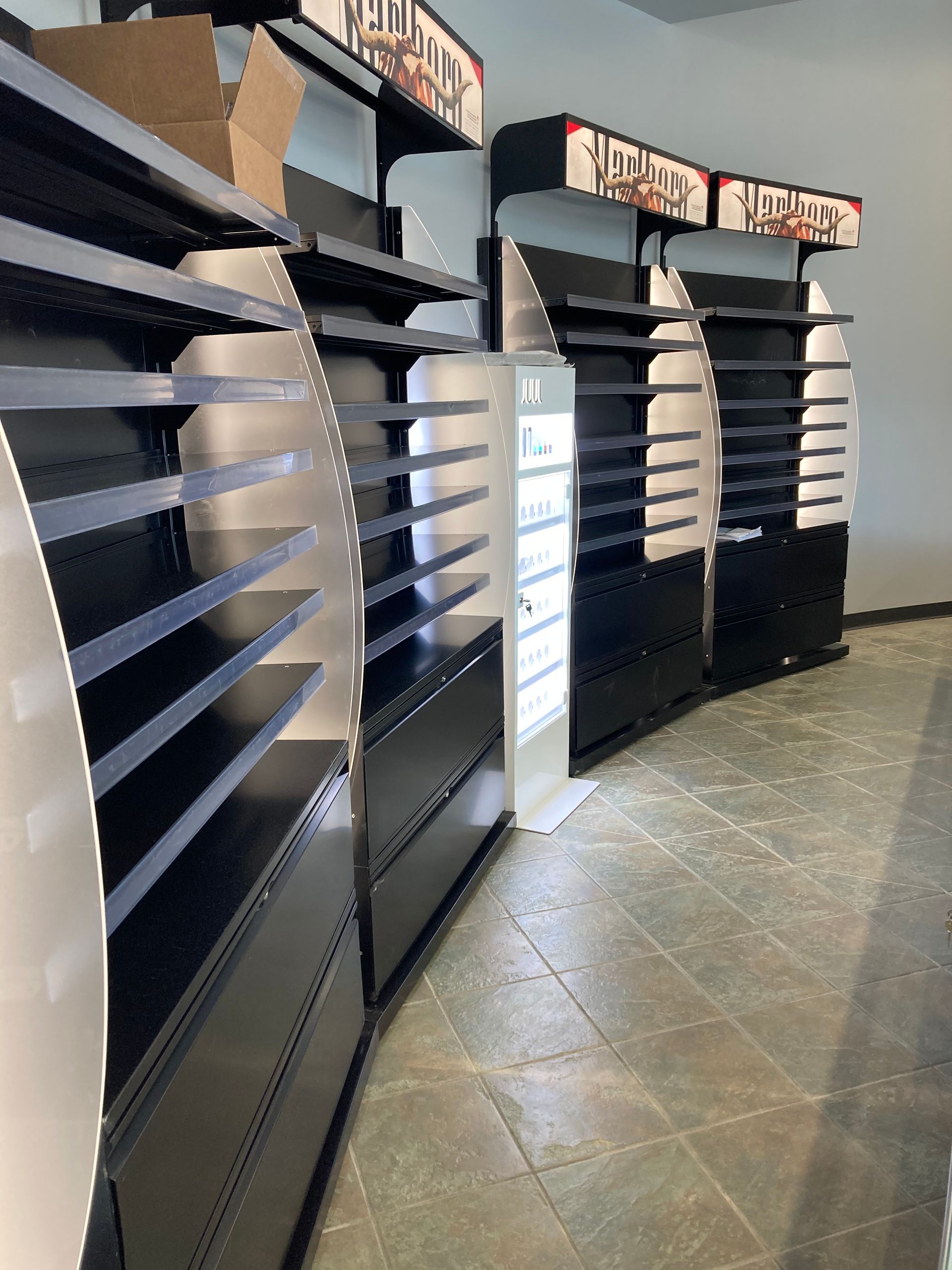 A row of empty shelves in a store with a sign that says lucky strike