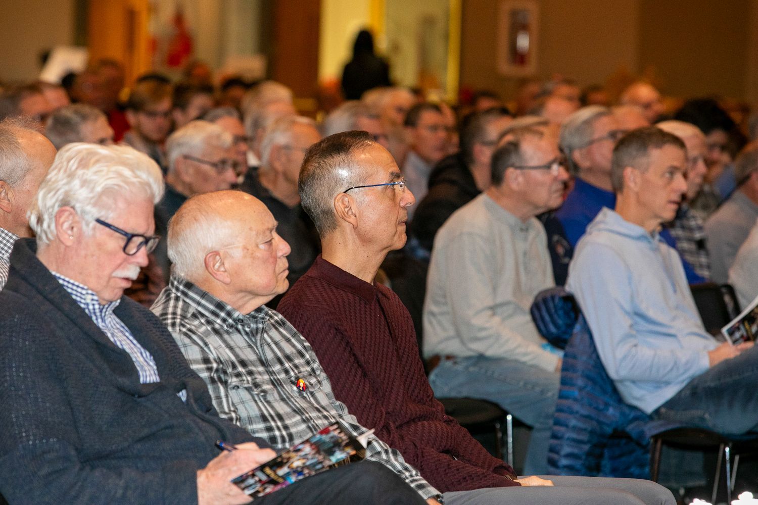 Audience seated in rows, listening attentively at a conference or lecture.
